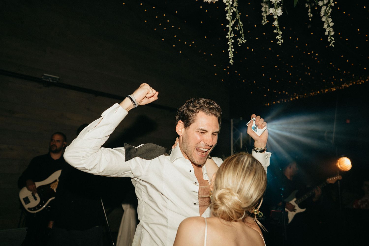 A couple dances together at a wedding reception with dramatic lighting and movement captured in the photograph.