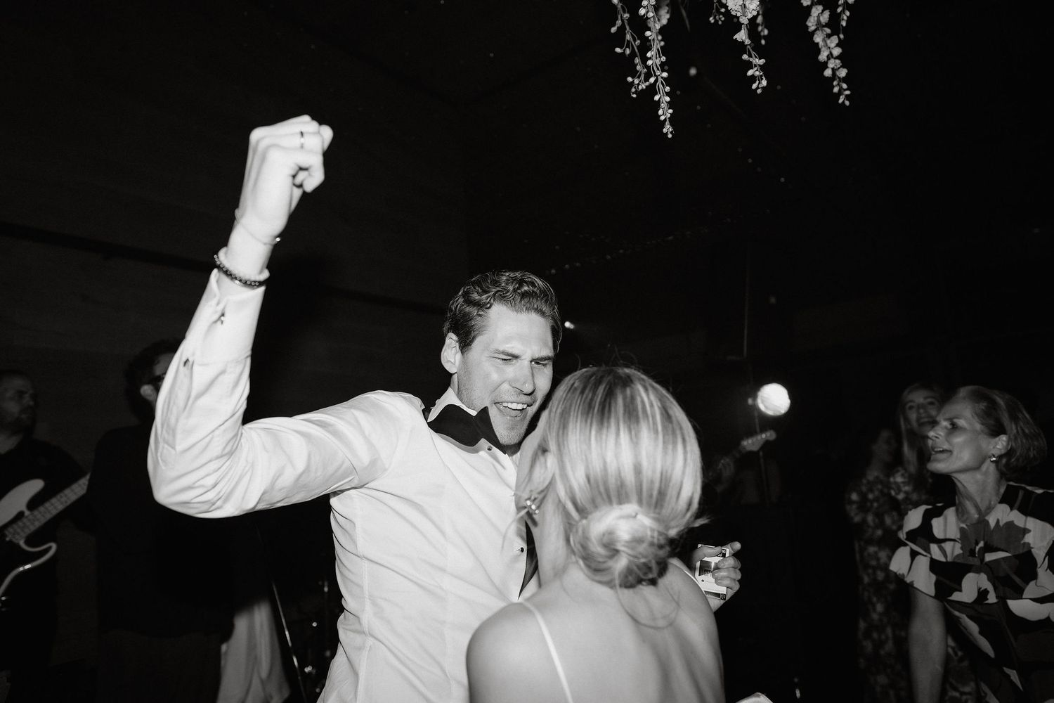 A series of black and white photos showing people dancing and celebrating at what appears to be a wedding reception.