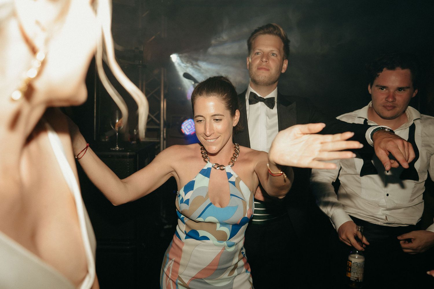 A series of blurry party photos showing people dancing and celebrating in a dimly lit nightclub setting.