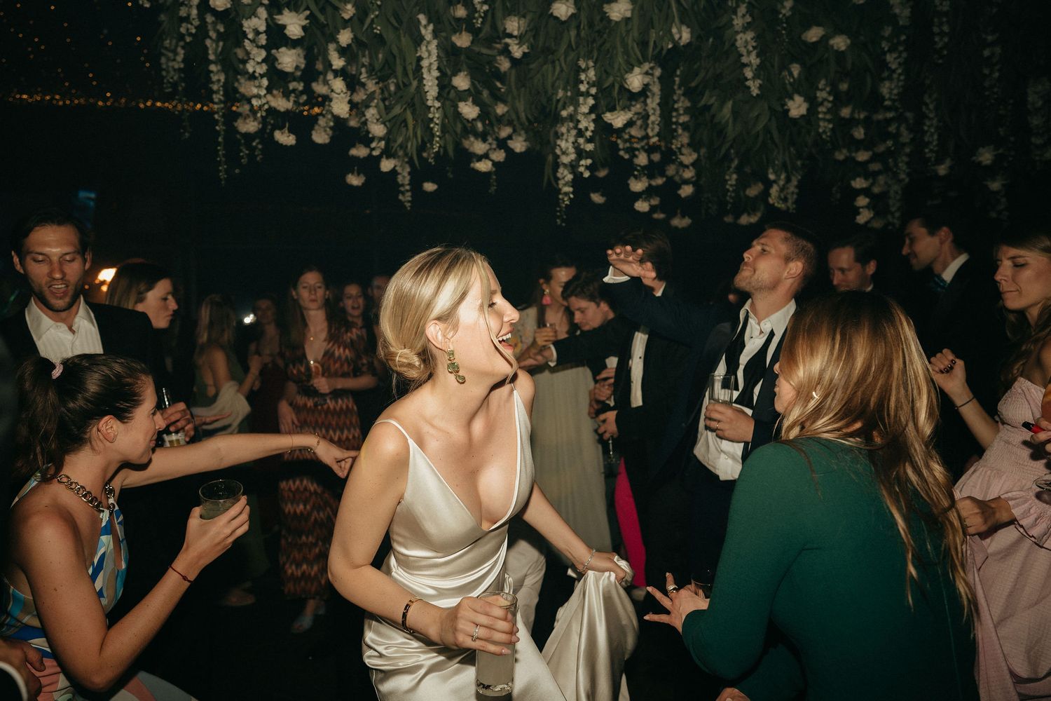 Couples dancing and socializing at a dimly lit party or nightclub event.