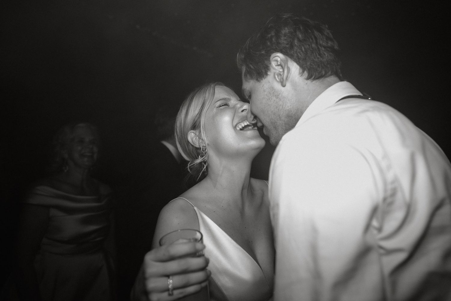 People dancing close together in an intimate black and white party scene.