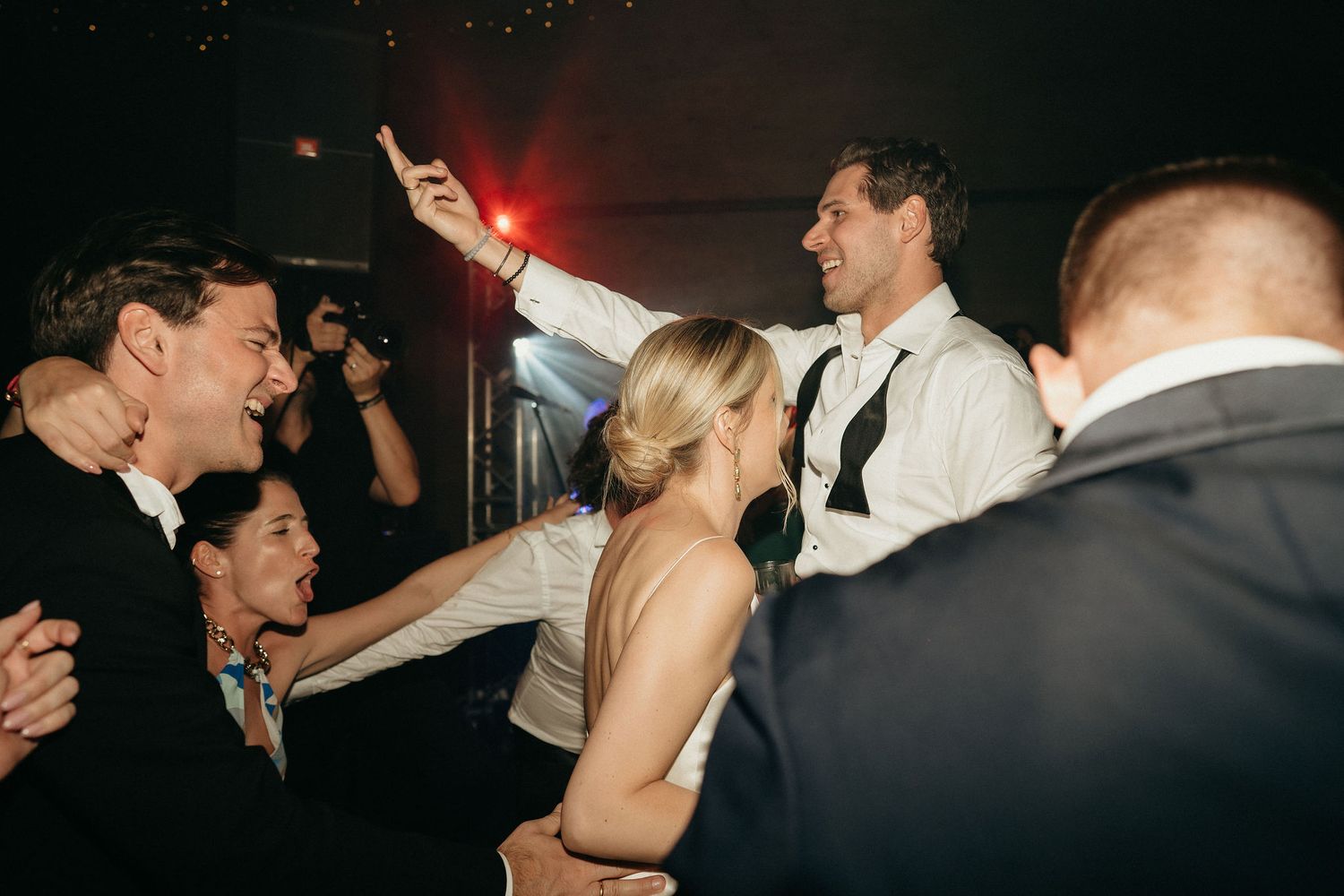 People dancing and socializing at a dimly lit nightclub or party venue.