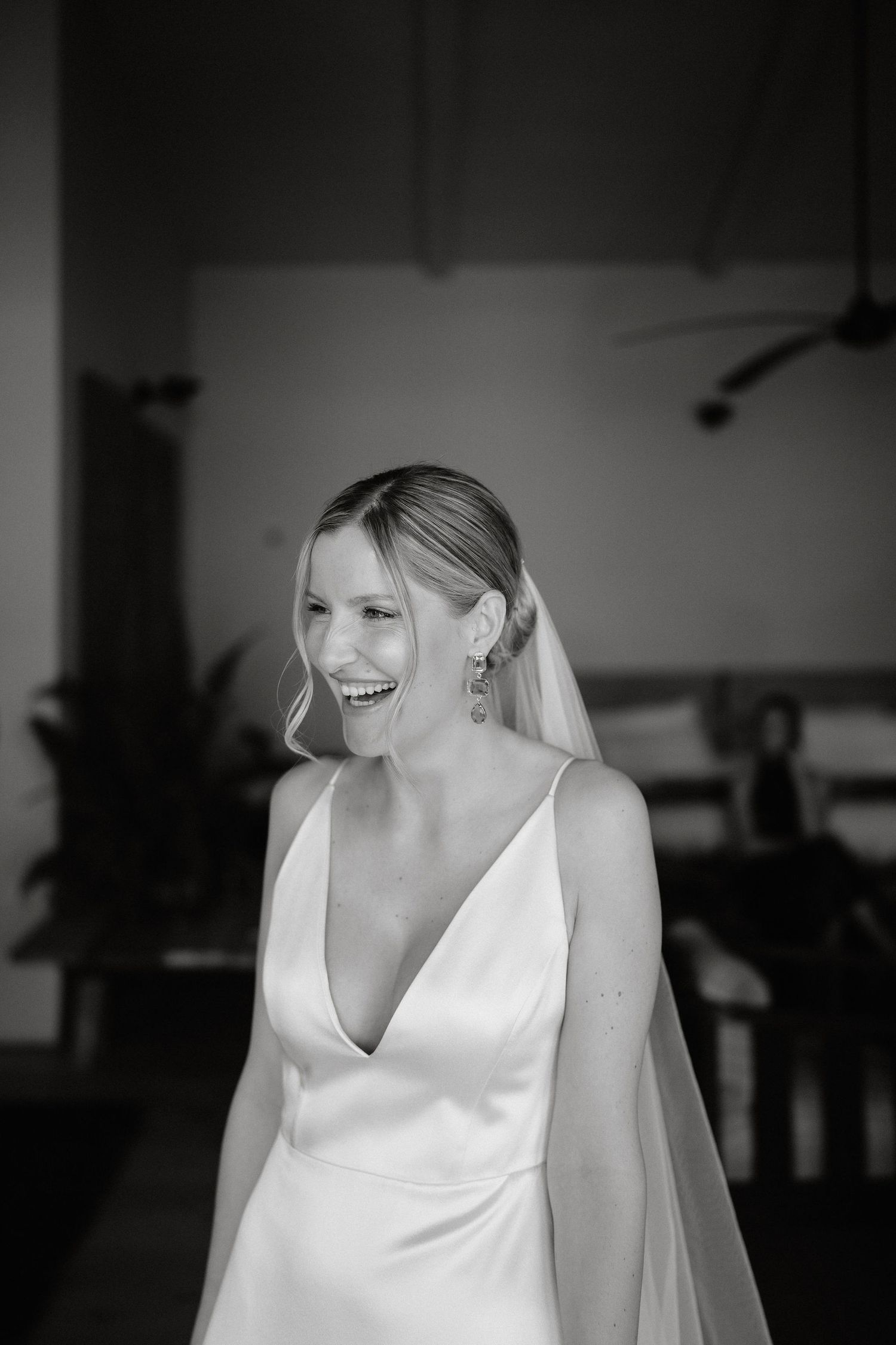 Black and white photo series showing joyful candid moments of a bride in a white wedding dress and veil.