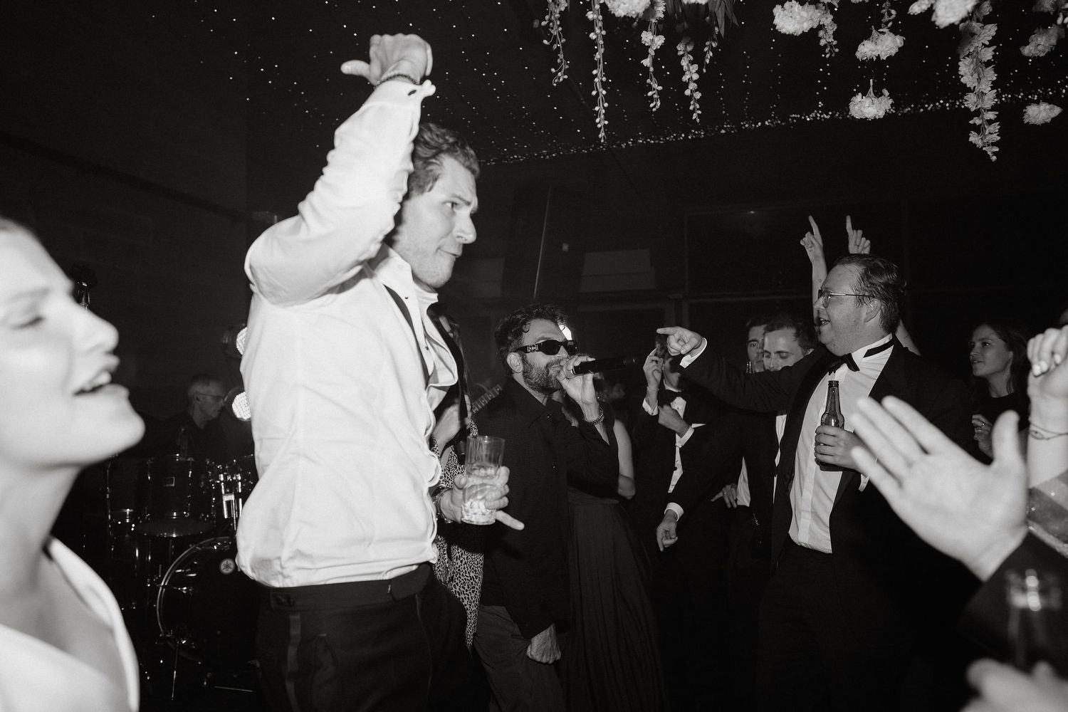 A group of people dancing and enjoying themselves at a lively nightclub in black and white.