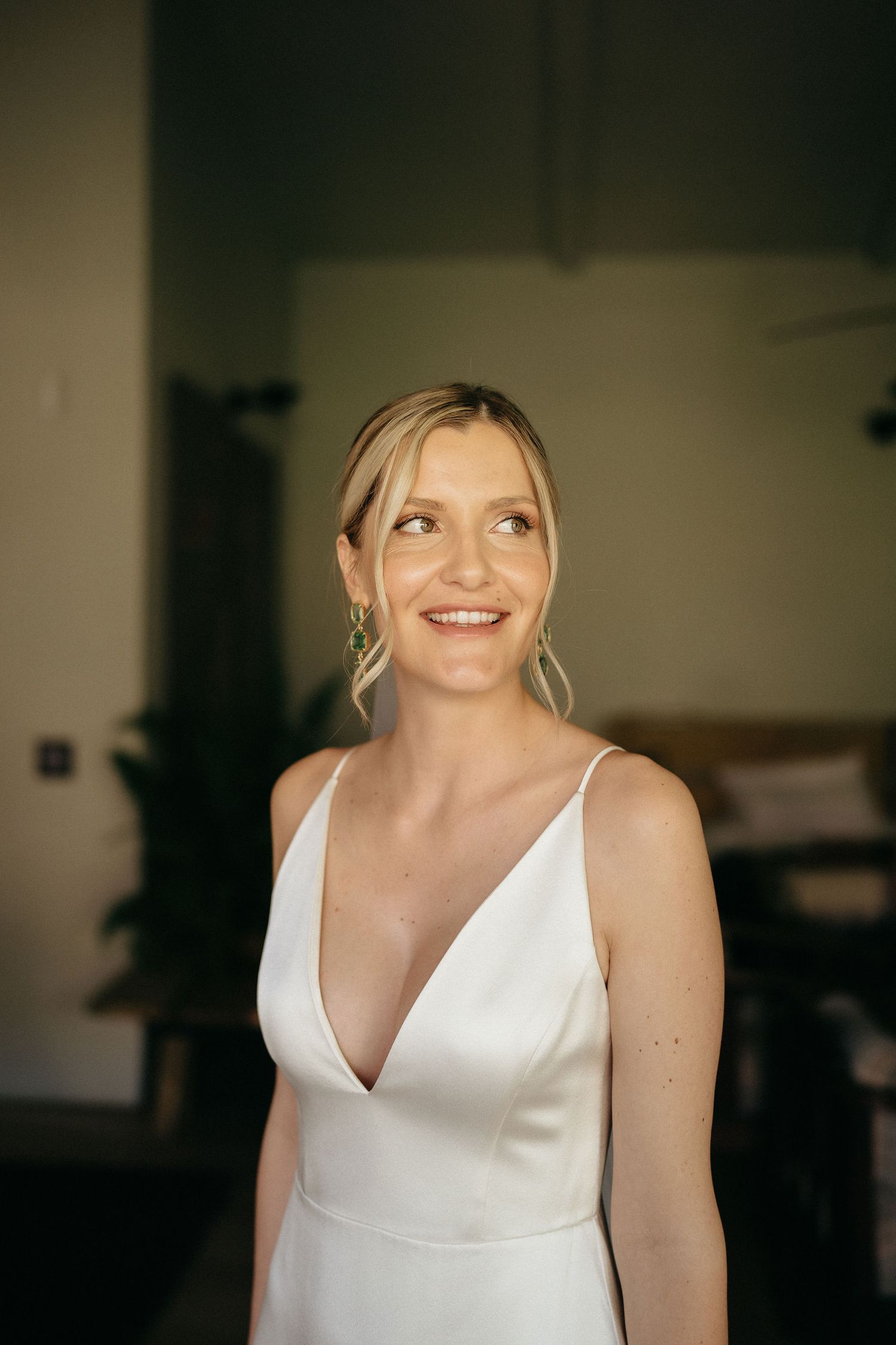 A sequence of close-up shots showing a white wedding gown in an indoor setting with natural lighting.