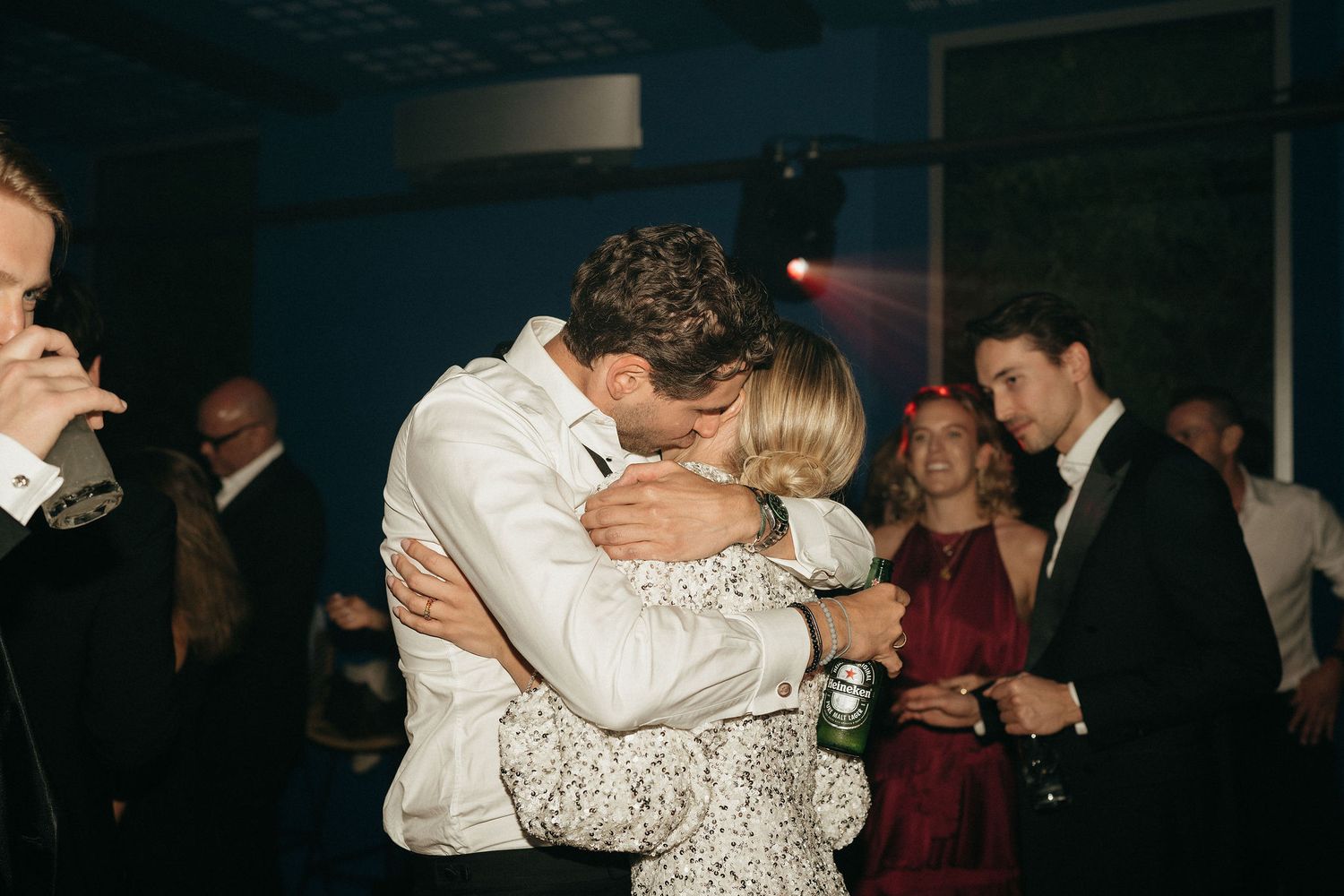 Couples dancing and embracing on a dimly lit dance floor at an elegant evening celebration.