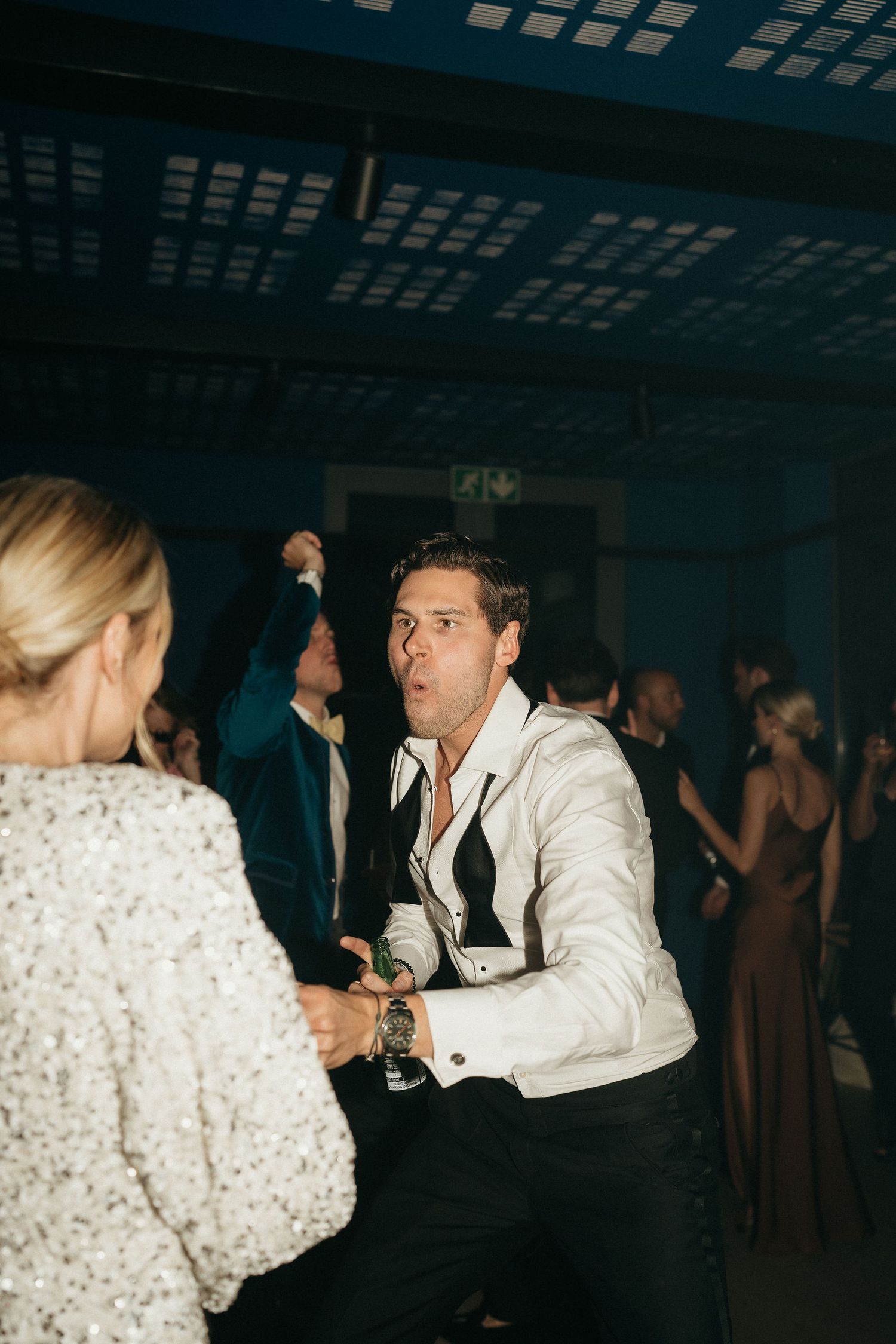 A sequence of dance moves captured at a formal event showing people in white and black attire on a dark dance floor.