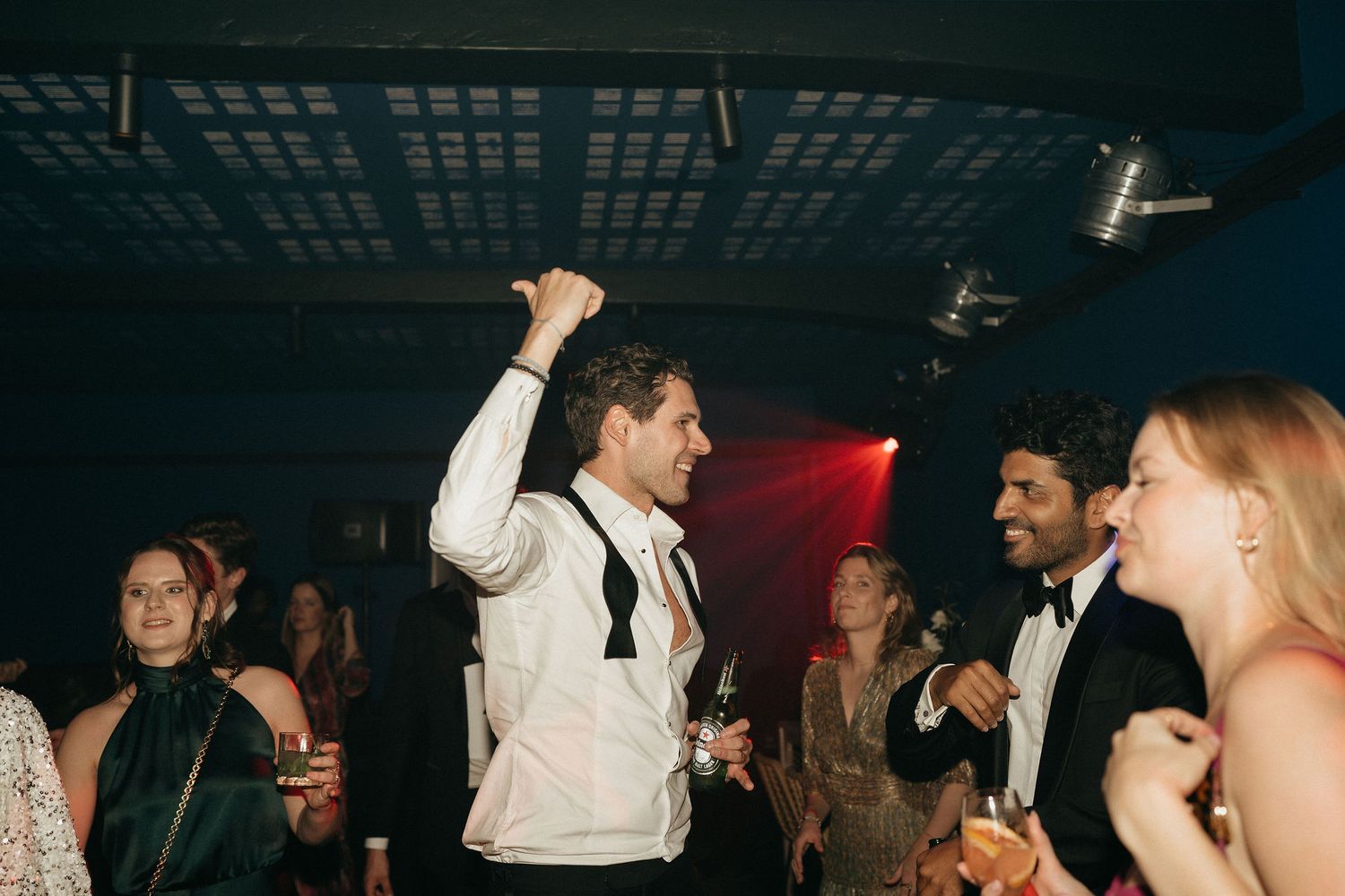 People dancing and enjoying themselves at a nightclub with atmospheric lighting and music.