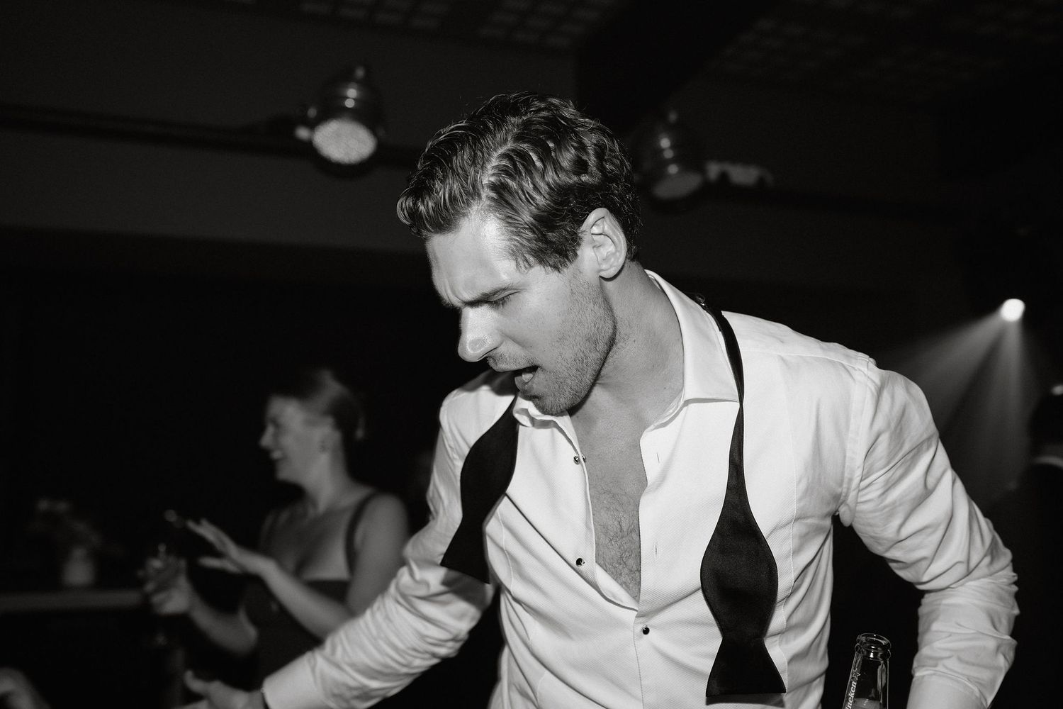 A black and white photo montage shows a performer in a white shirt singing on stage in different poses.