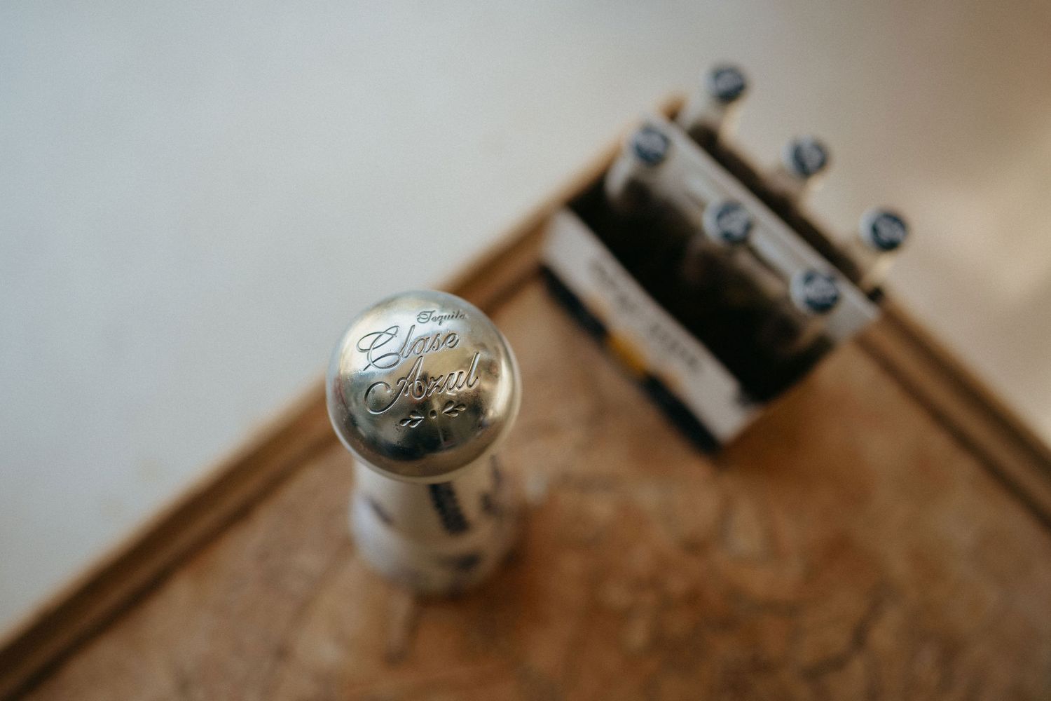 Close-up shot of a vintage brass doorknob with intricate details and patina against a blurred wooden door.