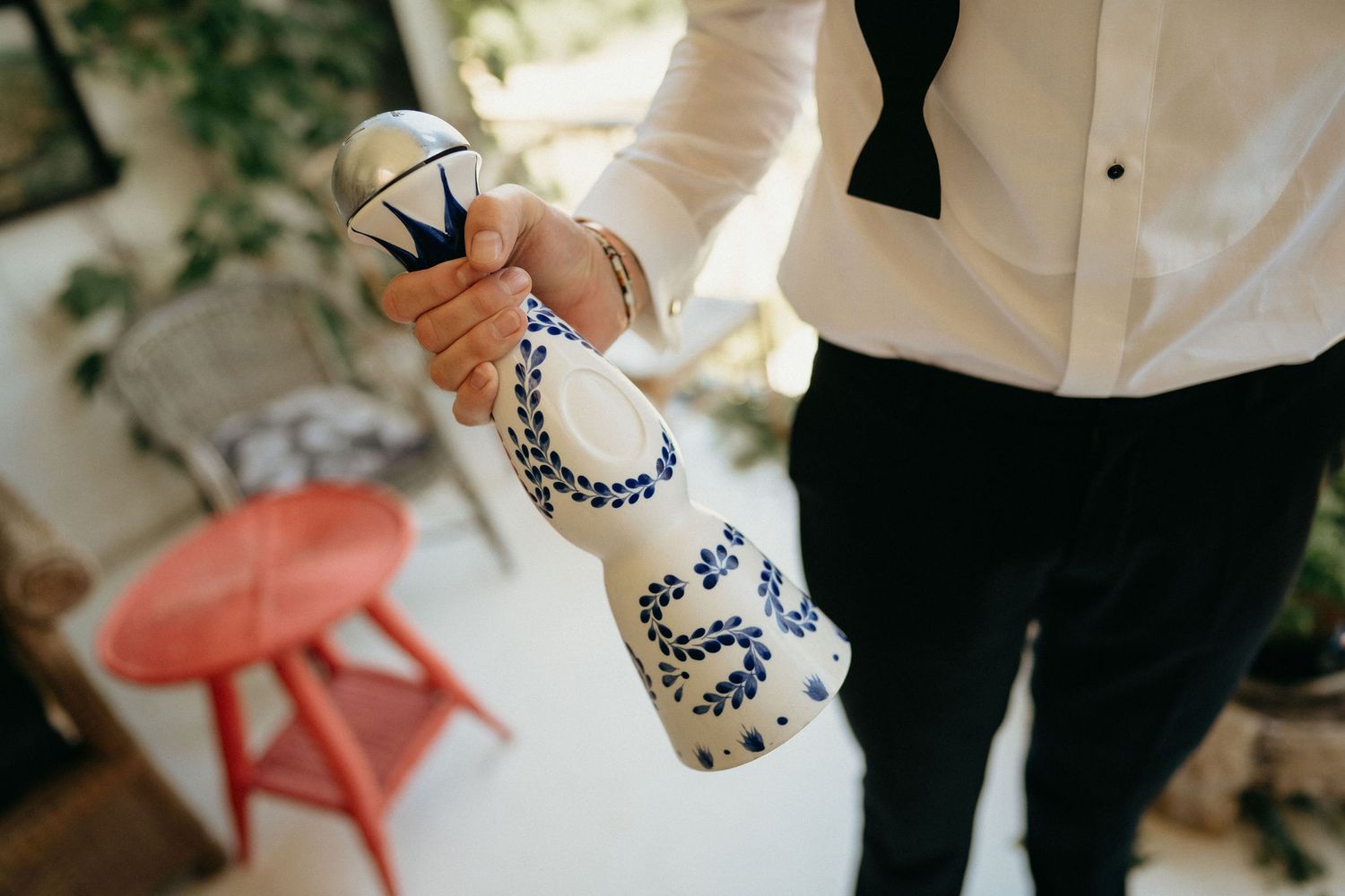 Close-up view of hands holding delicate china teacups at an elegant afternoon tea service.