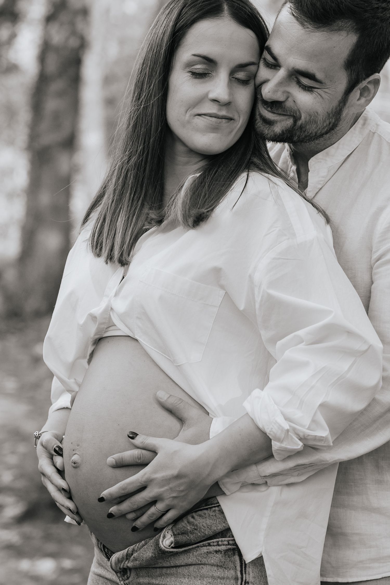 Black and white photo series showing a romantic couple in white shirts embracing outdoors in a tender moment.