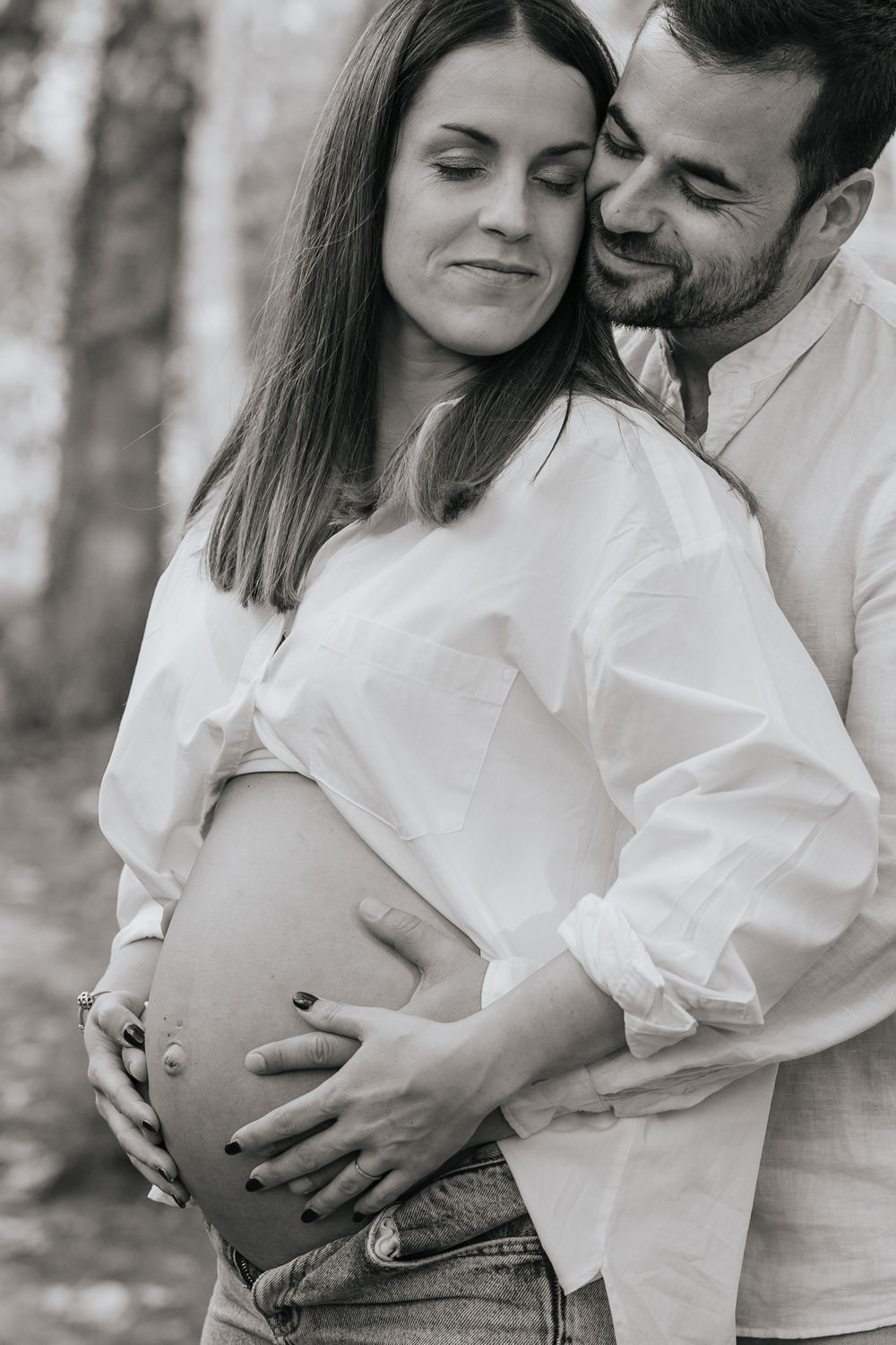 Black and white photo series showing a romantic couple in white shirts embracing outdoors in a tender moment.
