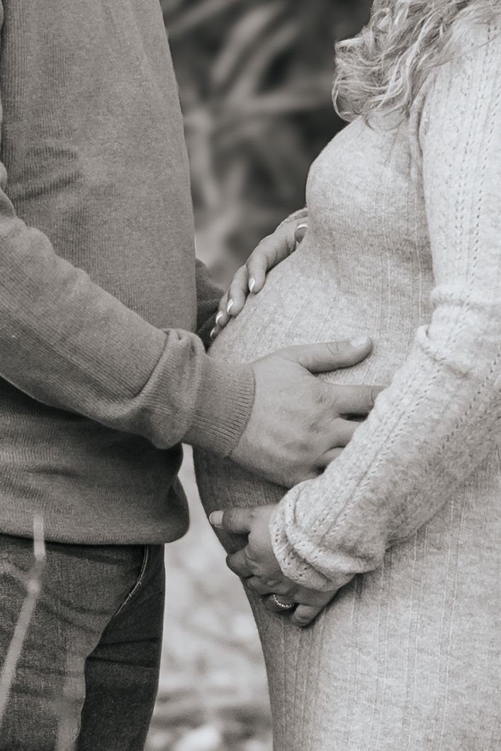 A series of black and white photos showing two people holding hands in cozy winter sweaters in a romantic pose.
