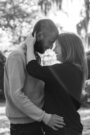A romantic black and white photo sequence of a couple dancing together under trees.
