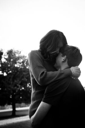 A series of black and white romantic silhouettes showing a couple embracing and kissing in an outdoor setting.