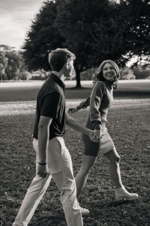 A black and white photo sequence shows two people dancing playfully together in a grassy outdoor setting.