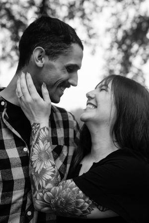 Black and white close-up of couple sharing tender moment outdoors.