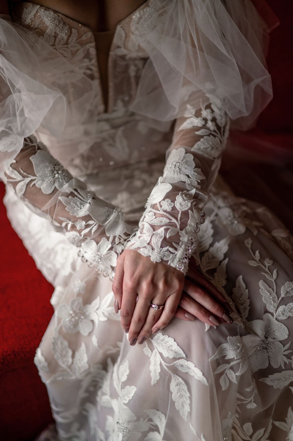 Close-up details of delicate lace sleeves and fabric textures on a wedding gown.