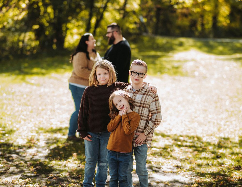 Family enjoying a sunny autumn day together in a park setting.