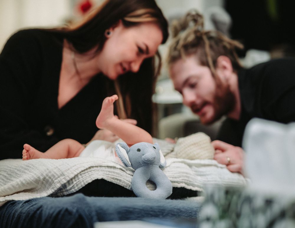 Candid moments of laughter and joy shared over a gray travel pillow.