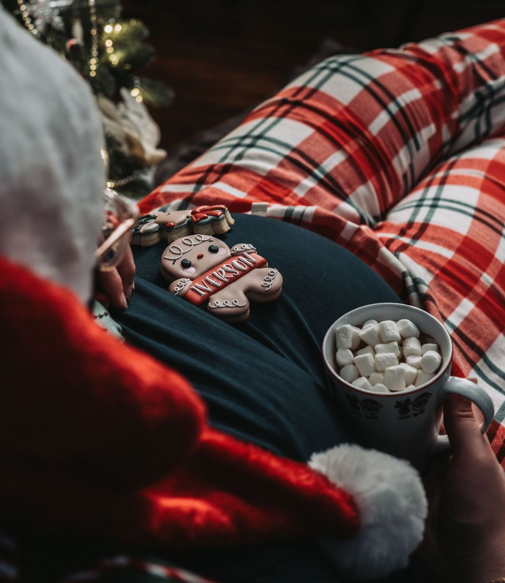 Hot cocoa with marshmallows on a red plaid blanket during Christmas.