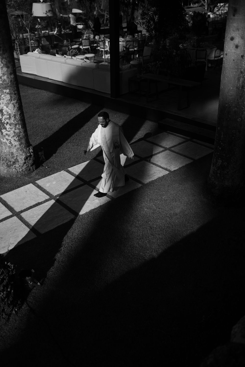 Dramatic black and white image showing shadows cast through windows onto a checkered floor.
