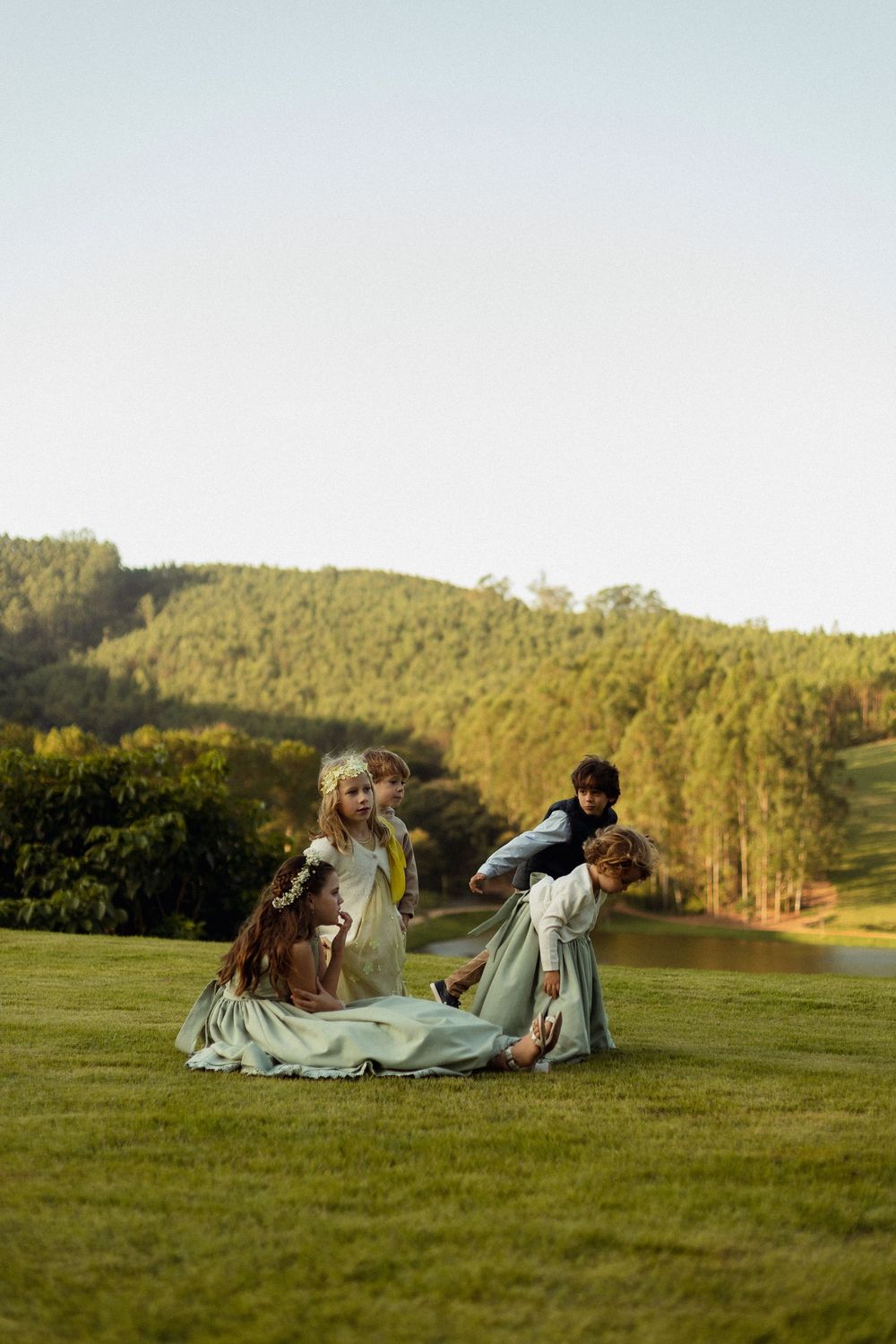 Wedding couple laying on grassy hill during sunset photo session.