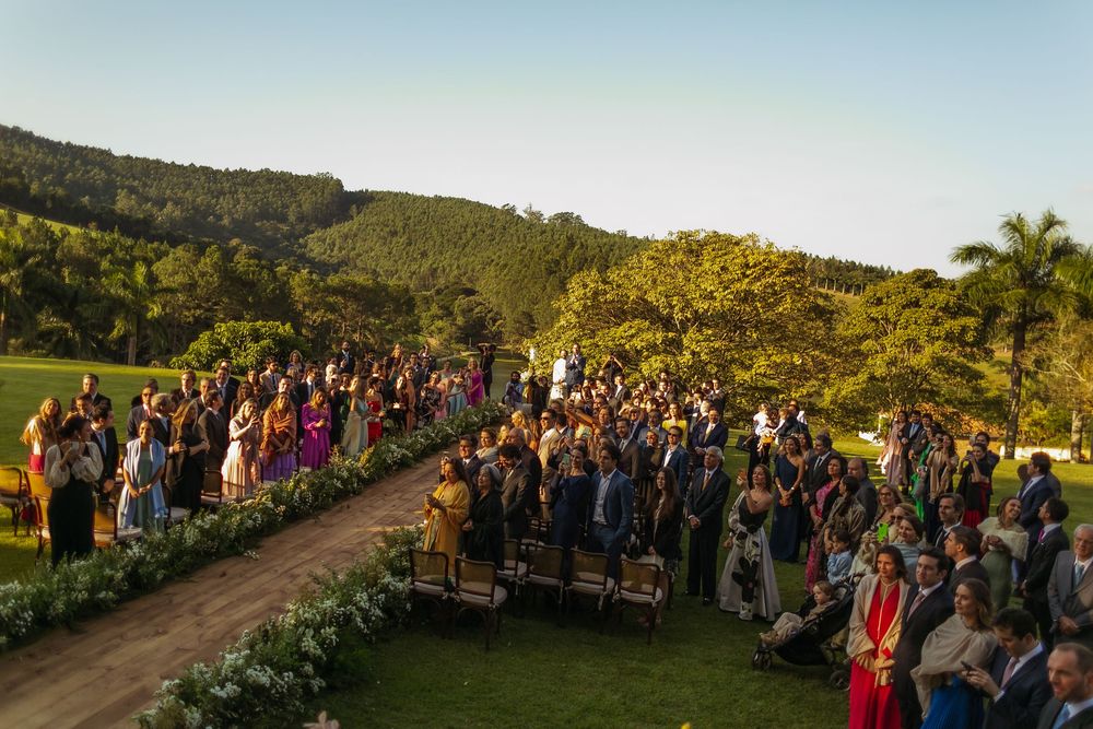 Aerial view of wedding guests seated along a curved pathway with mountain views.
