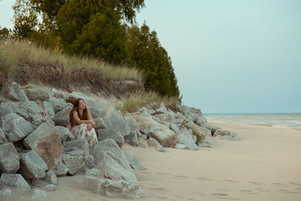 Seven scenic coastal landscape photos show a rocky beach with dunes and vegetation along a tranquil shoreline.