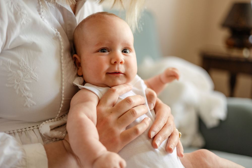 a baby sits on a mother's lap