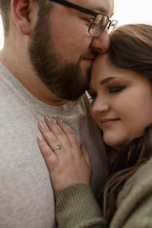 A tender close-up of a couple sharing an intimate moment outdoors.