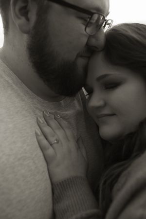 Black and white intimate portrait of a couple sharing a tender moment together.
