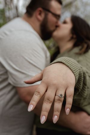 A close-up shot of hands showing off an engagement ring during a romantic moment.