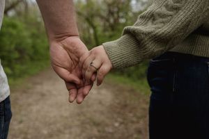 Detail shot of hands and casual clothing during an outdoor photo session.