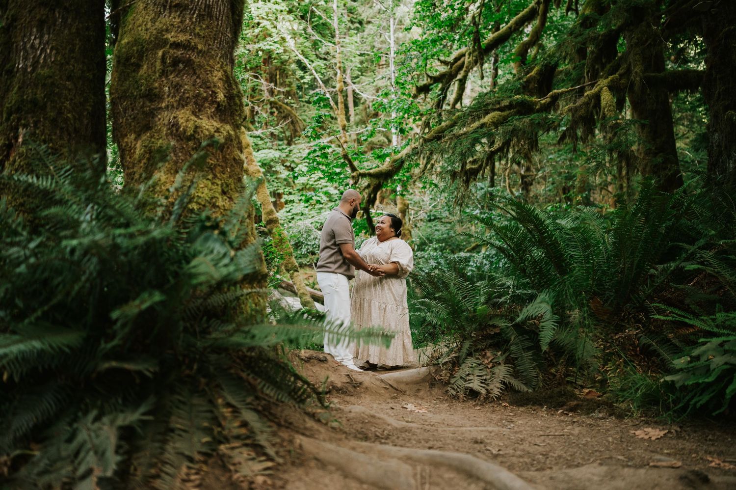 Photography of engaged couple holding hands in Cathedral Groves, MacMillan Park forest. Vancouver Island adventure photographer