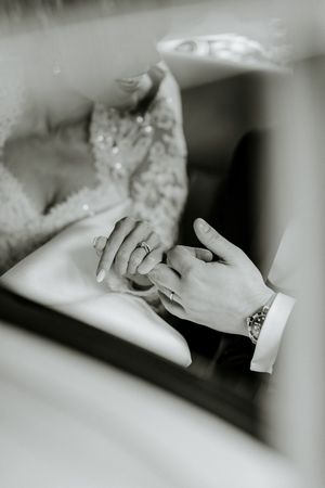 Close up black and white photo of hands holding and sculpting clay on a surface.