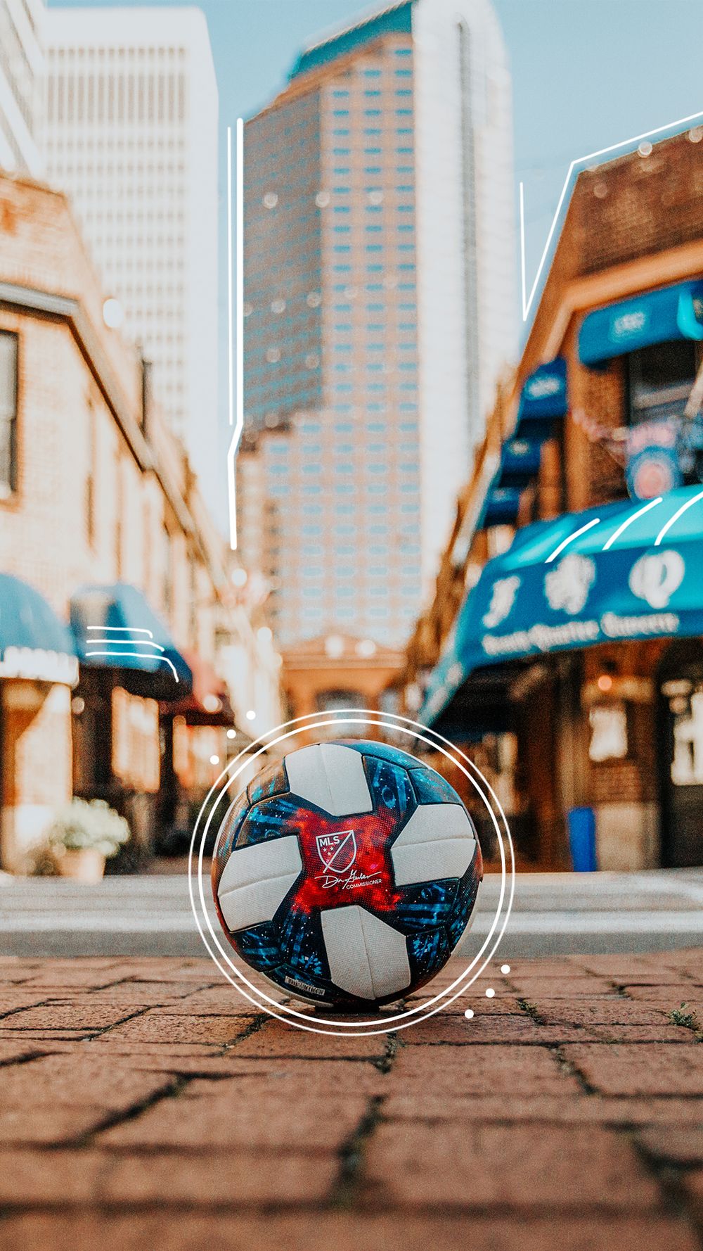 MLS soccer ball on a brick street in Charlotte with city buildings in the background.
