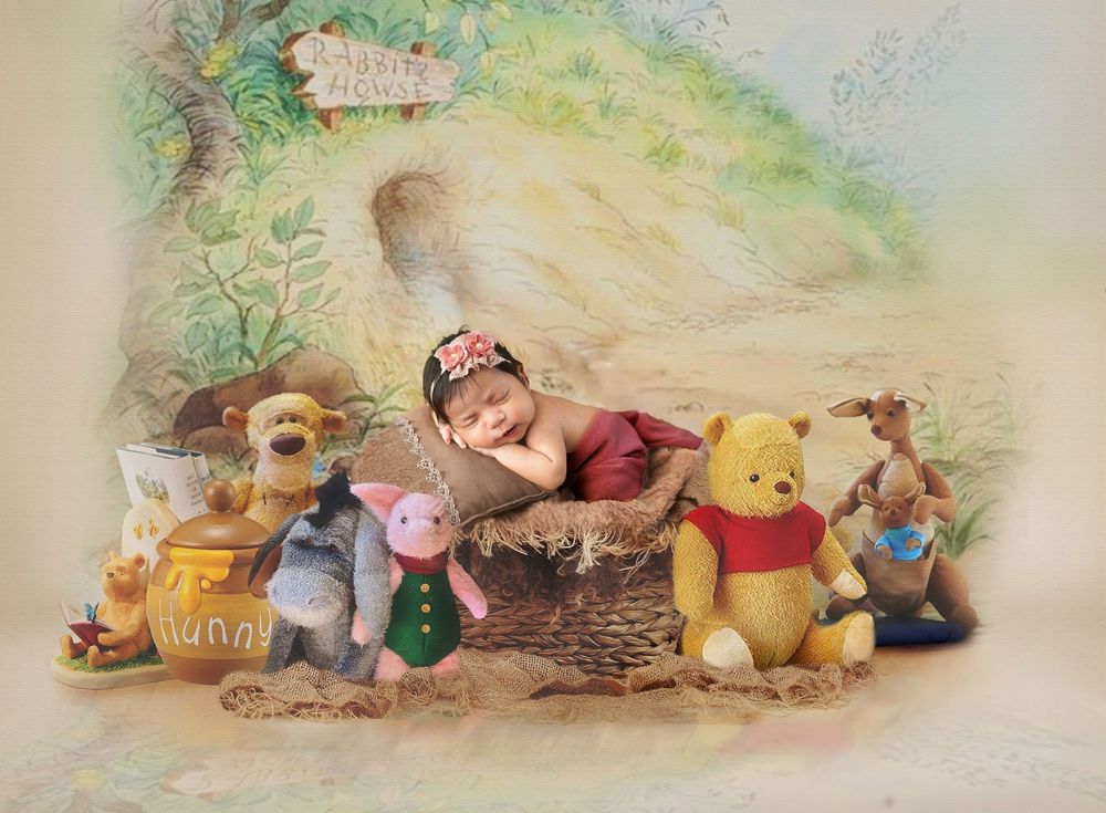 A whimsical baby portrait featuring Winnie the Pooh characters including Tigger, Piglet, Pooh Bear and others surrounding a basket.