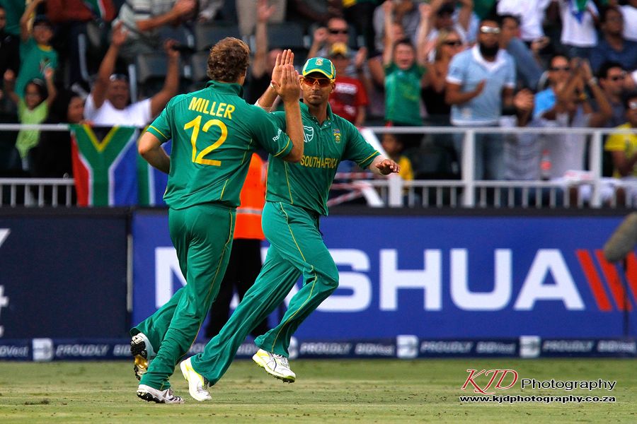 Cricket players in green jerseys celebrate on the field during a match with the Huawei banner visible in background.