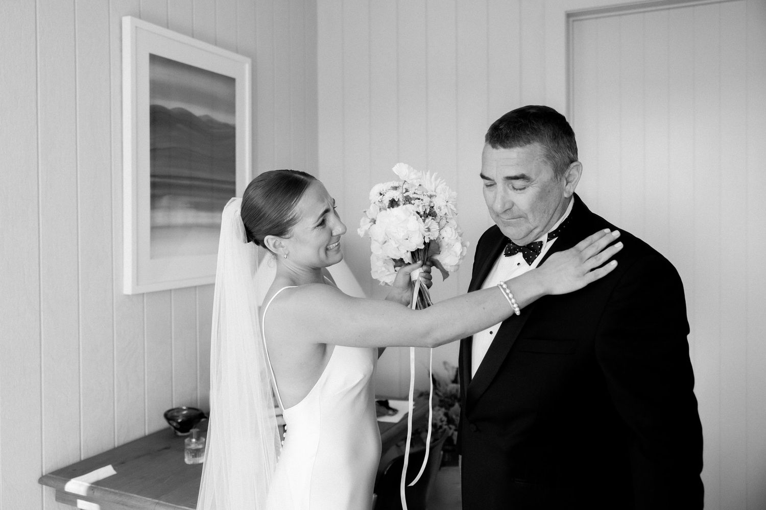 A bride and groom share an emotional candid moment in black and white while getting ready for their wedding ceremony.