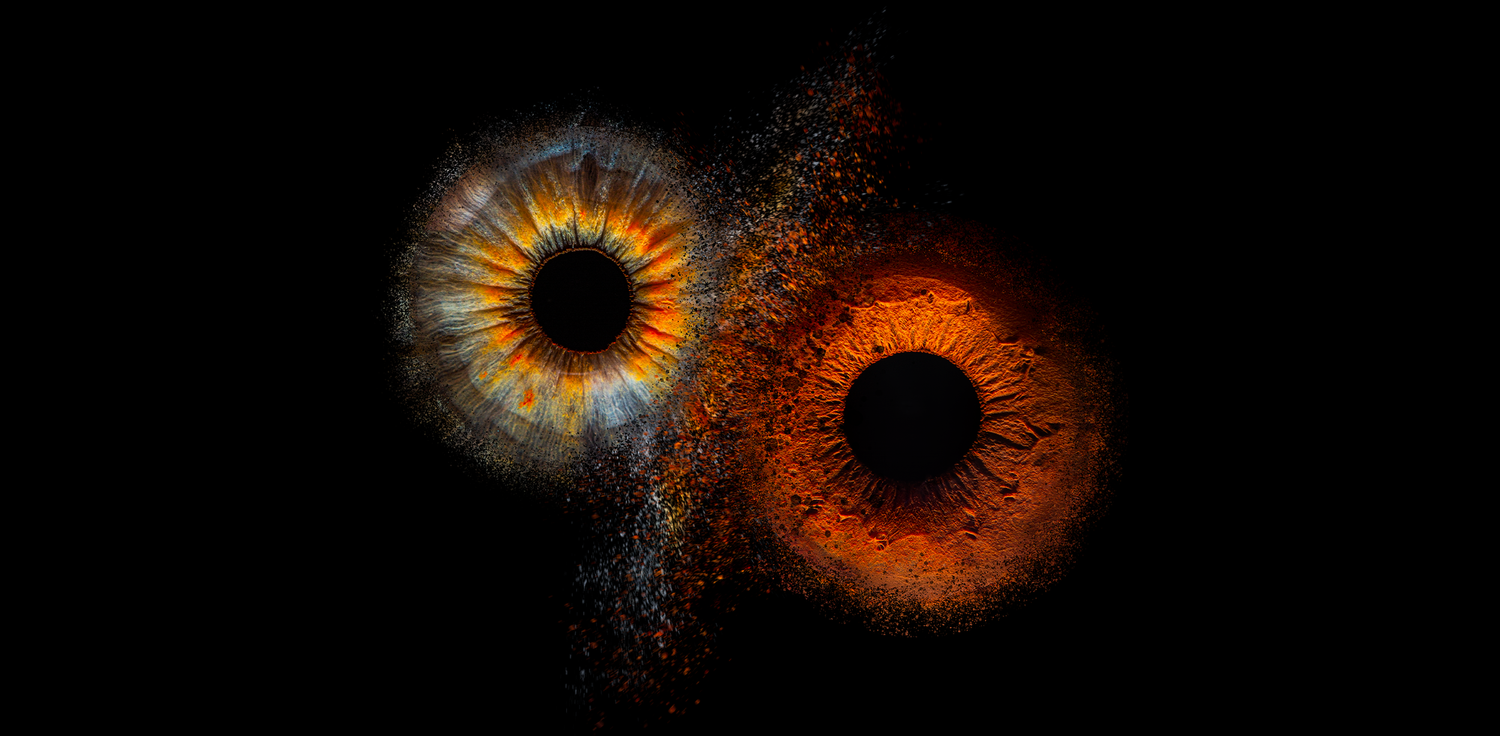 Creative digital artwork showing two contrasting eye irises with smoke effect on black background.