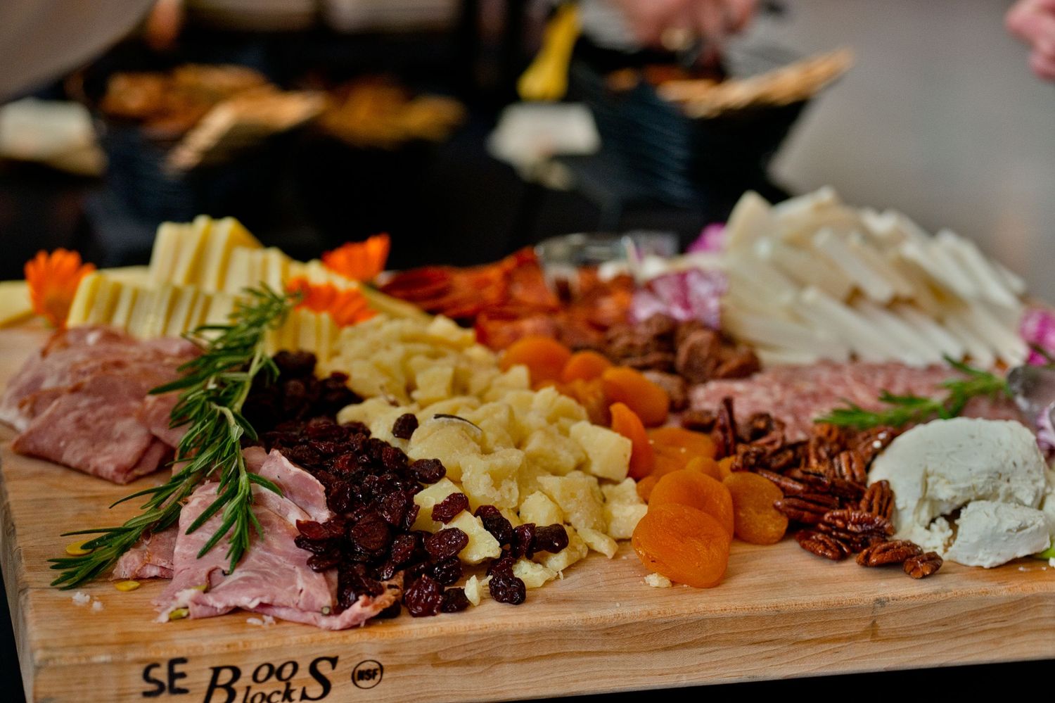 A wooden charcuterie board filled with meats, cheeses, olives, and assorted snacks arranged for entertaining by CIA Copia, Napa Valley, CA.