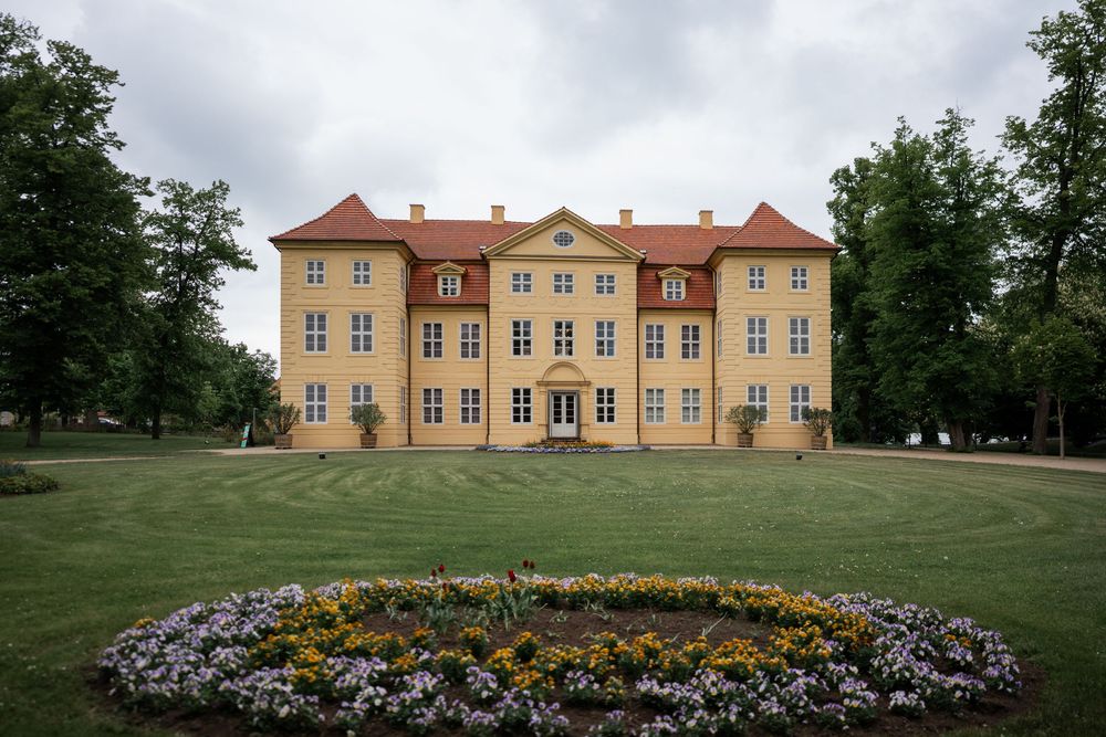 Außenansicht vom Schloss Mirow mit Blumenbeet im Vordergrund, Sommerhochzeit