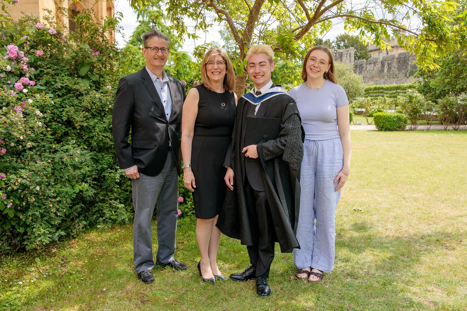 Group photos taken outdoors in a garden setting during a graduation celebration.