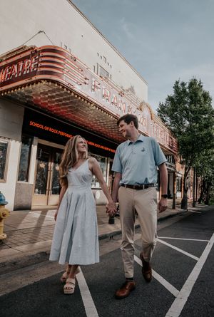 Engagement photoshoot outside vintage movie theatre with art deco architecture.