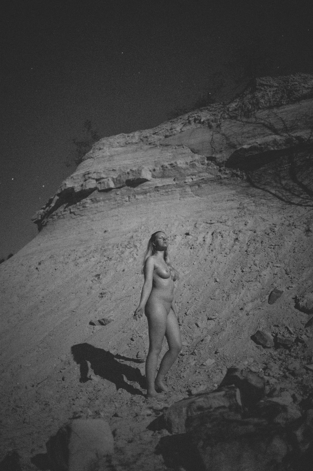 A series of black and white photographs depicting rocky terrain in dramatic moonlit or low-light conditions.