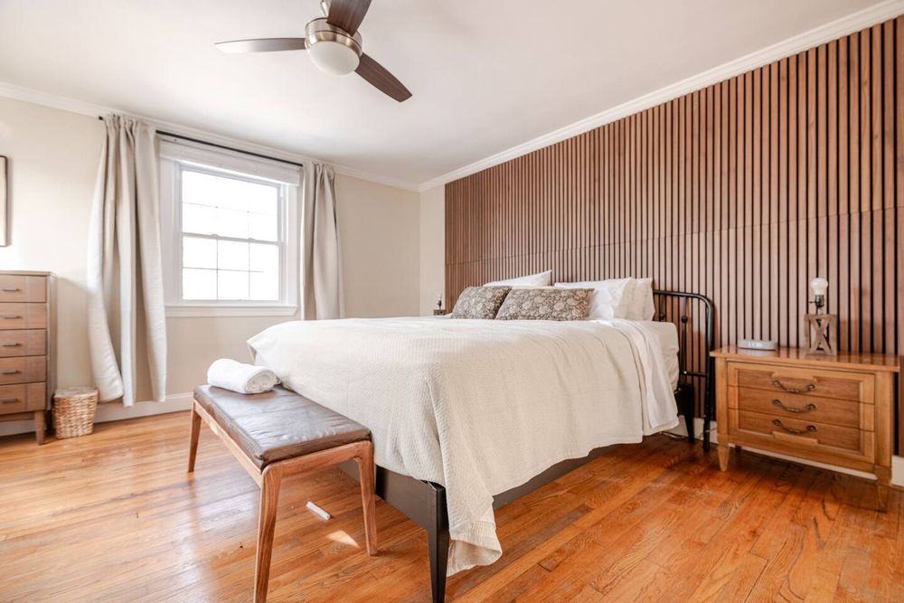 Mid-century modern bedroom with bed and large window in Baltimore County. Real estate photography by Photograph Maryland.