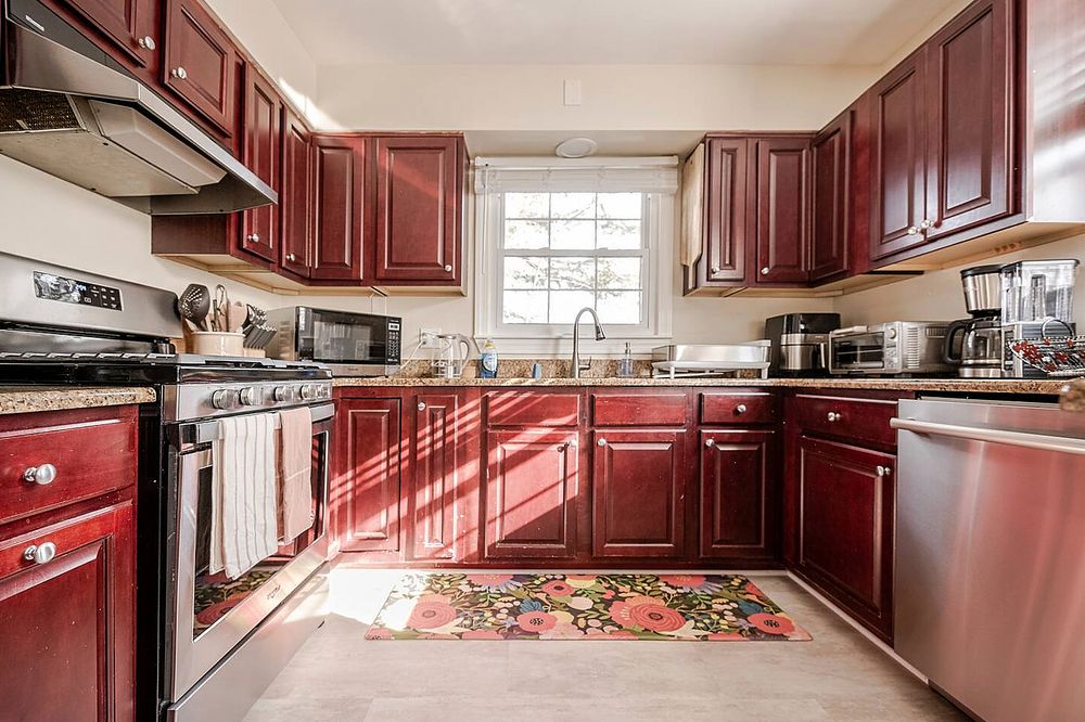 Unique kitchen design featuring burgundy cabinets and hardwood floors in Baltimore County home.