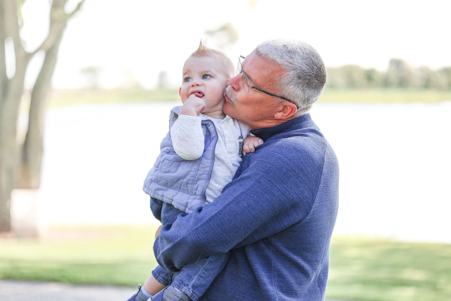 Springfield, IL family photographer captures a grandpa kissing his grandson's cheek during a photo session in Central, IL